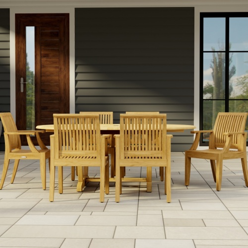 70306 Martinique 7 pc Teak Dining Set of Martinique Teak Oval Extending Dining Table and 6 Laguna DIning Chairs side view on stone patio with house window and door in background