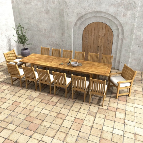 70361 Grand Laguna 15 piece teak Dining Set of 12 teak dining chairs around teak rectangular dining table angled view on paver patio and potted tree and door in background 