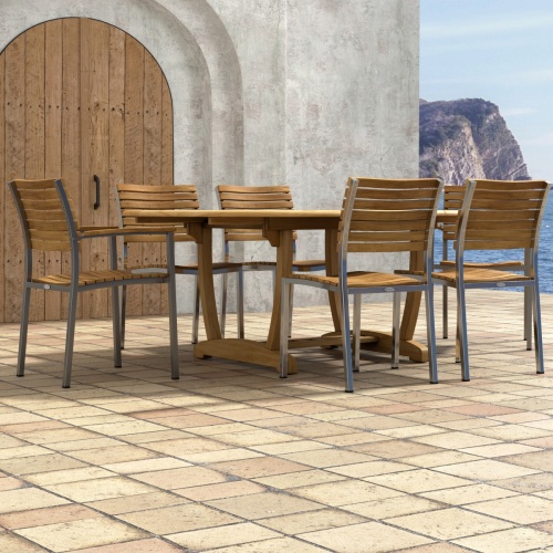 70370 Martinique Veranda 7 pc Oval Dining Set of Martinique Teak Oval Dining Table and 2 Veranda Armchairs and 4 Side Chairs on a patio and wood doors and ocean in background