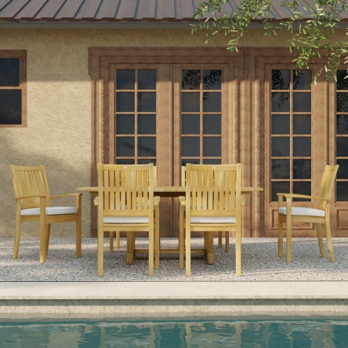 70372 Oval Sussex Chair 7 pc Dining Set of Martinique Teak Oval Table and 6 Sussex Dining Chairs on outdoor terrace overlooking a pool and french doors in the background