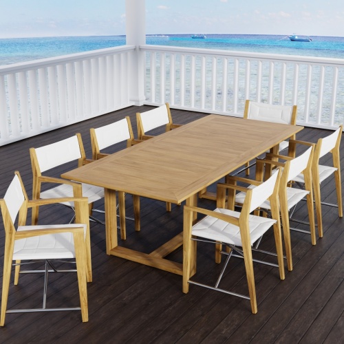 70366 Oval Odyssey Chair 7 pc Dining Set of Martinique Oval Table and 6 Odyssey Director Chairs on outdoor terrace next to palm tree and ocean and mountain background