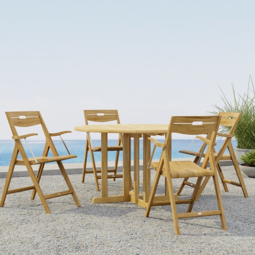 70376  Surf Barbuda 5 pc Folding Dining Set of 4 Surf folding Dining Chairs and a Barbuda 48 inch Round Table on outdoor terrace with 2 potted plants and the ocean in the background