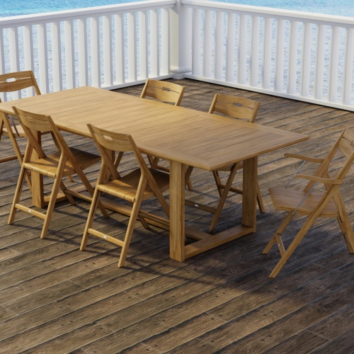 70378 Horizon Surf 7 pc Dining Set of Horizon Dining Table and 2 Surf Folding Dining Armchairs and 4 Side Chairs on wood patio with white deck railings and the ocean in the background