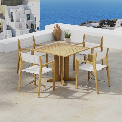 70455 Odyssey Pyramid 5 piece Bistro Set of Pyramid 36 inch Square Table and 4 Odyssey Folding Chairs angled on outdoor terrace overlooking houses and the ocean