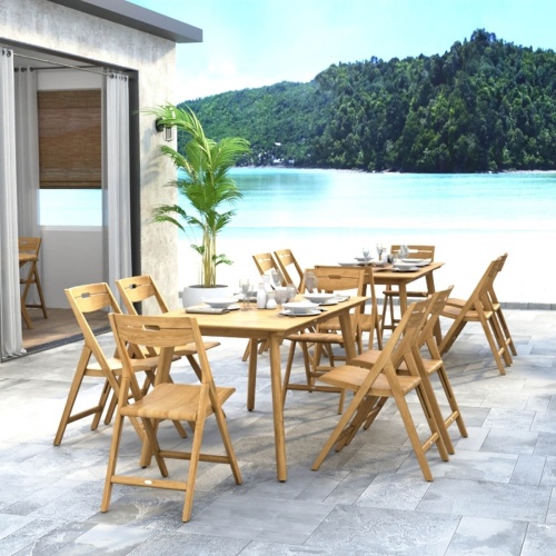 70518 Surf 7 piece teak folding Dining Set showing 2 Dining Sets in hospitality setting on patio with table settings and glasses and potted tree with ocean blue sky and land in background