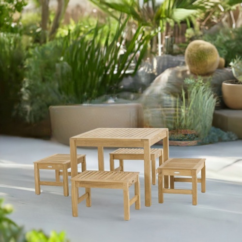 70520 Brunswick 5 piece Cafe Set of 4 teak 24 inch long stools side and 36 inch square teak table side view on patio surrounded by plants and trees in background