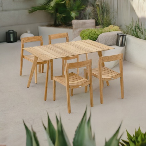 70526 Surf Horizon 5 pc Teak Dining Set of  Surf Teak Rectangular Table and 4 Horizon Side Chairs end angled on patio with plants and trees in planters in background