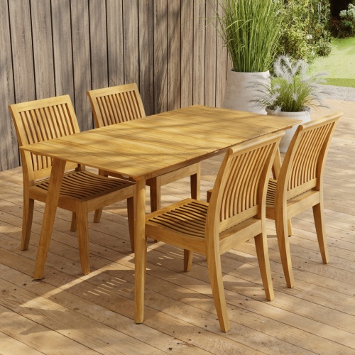 70571 Surf Laguna 5 pc Teak Dining Set of Surf Teak Rectangular Table and 4 Laguna Side Chairs on wood deck in front of a privacy wall and 2 potted plants and lawn in background