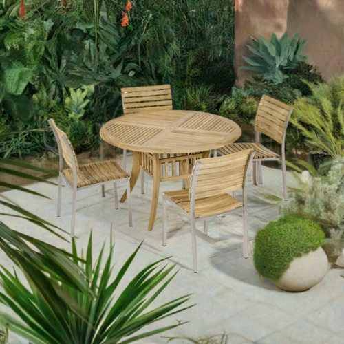 70580 Grand Hyatt Vogue 5 pc Dining Set of Grand Hyatt 48 inch Round Teak Table and 4 Vogue Teak and Stainless Steel Dining Side Chairs on patio with plants in the background