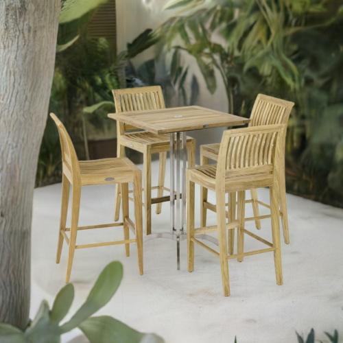 70638 Laguna Vogue Teak Square Bar Set of 36 inch square teak and stainless steel bar table and 4 teak side barstools angled on patio surrounded by landscaping plants and trees