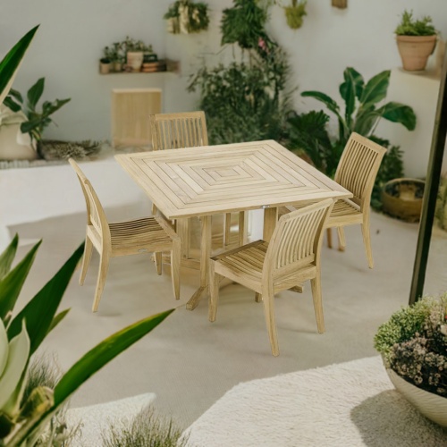 70711 Laguna Pyramid 5 piece Dining Set of 4 teak side chairs and 48 inch square dining table angled top view on concrete patio surrounded by tropical plants ptted and hanging on wall in the background