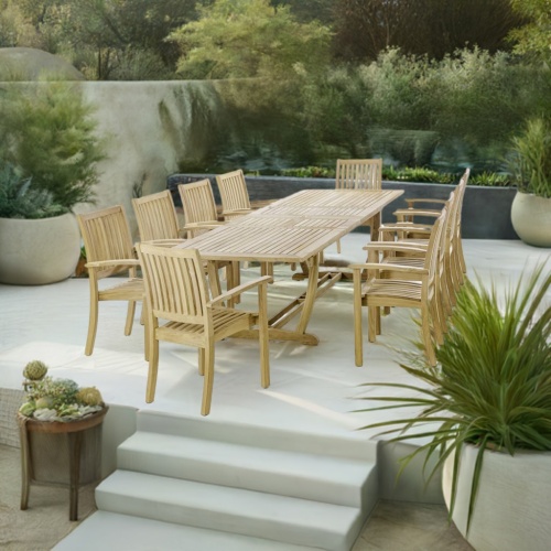 70758 Sussex Veranda 11 piece teak dining set of 10 teak dining armchairs and rectangular dining table end view on white terraced patio with potted and landscaping plants in background