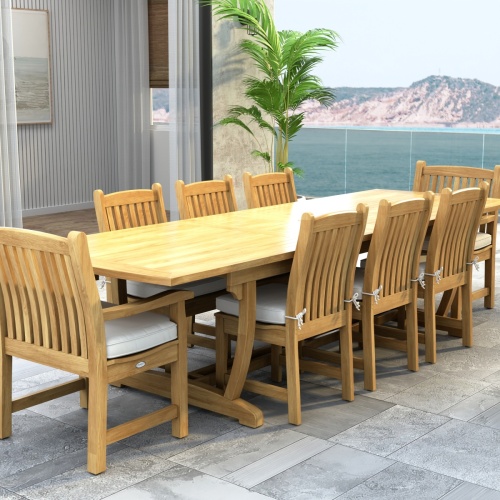 70792 Veranda 9 pc Teak Dining Set of Veranda Rectangular Extending Dining Table and 2 Dining Arm Chairs and 6 Side Chairs with optional seat cushions and a potted plant and ocean view background