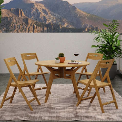 70811 Surf Yacht teak round 42 inch Folding 5 piece Dining Set on terrace showing with 2 potted plants and book on table next to potted tree with mountain background