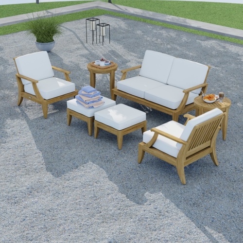 70877 Laguna 7 piece teak Love Seat Set aerial view on stone patio with rolled towels on ottoman with grass lawn in background 