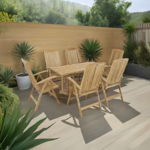 70903 Nevis Barbuda 7 piece Recliner Dining Set of 6 Barbuda dining chairs and Nevis teak rectangular table angled view on patio with landscaping trees and privacy fence in the background  