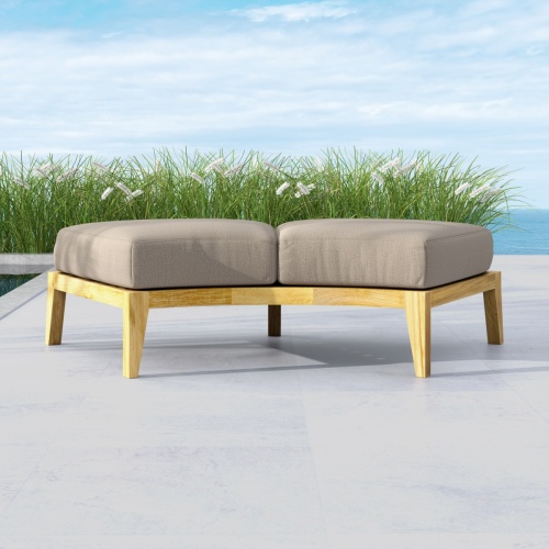 13342DP Kafelonia Backless Curved Sofa Sectional with optional cushion front view on outdoor patio with landscape grass and ocean n background