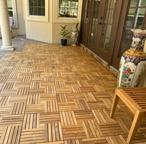 18412P Parquet Teak Tiles  assembled on a outdoor patio with french door and potted palm and tall vase and teak table against a house