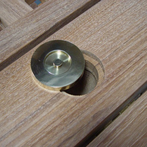 40013 Brass Umbrella Table Plug closeup view partially covering umbrella hole