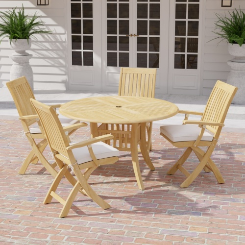 70043 Grand Hyatt Barbuda 5 pc Patio Dining Set of Grand Hyatt Dining Table and 4 Barbuda Folding Chairs angled on a brick paver patio with french doors and 2 potted ferns in background