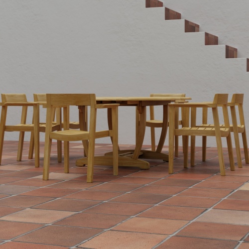 70364 Martinique Horizon teak 7 pc Dining Set of Martinique Dining Table and 6 Horizon Armchairs in side profile on tiled outdoor terrace surrounded with staircase of house in background