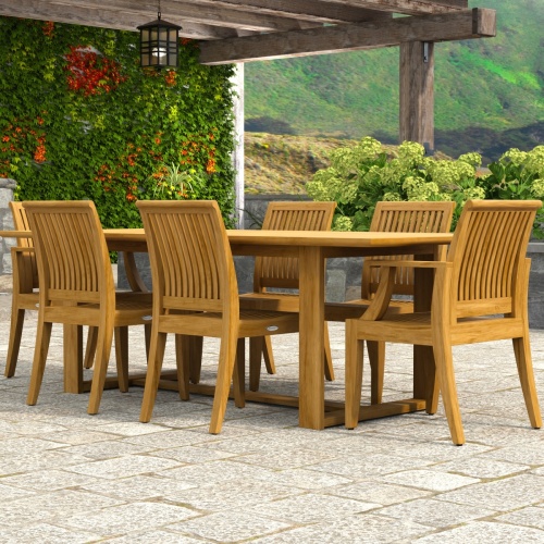 70377 Horizon Laguna 7 pc Teak Dining Set of Horizon Dining Table and 2 Laguna DIning Arm Chairs and 4 Laguna Side Chairs on paver pergola patio with landscaping plants and hillside in the background 