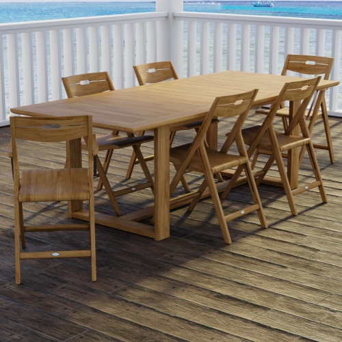 70378 Horizon Surf 7 pc Dining Set of Horizon Dining Table and 2 Surf Folding Dining Armchairs and 4 Side Chairs on wood patio with white deck railings and the ocean and boats in the background