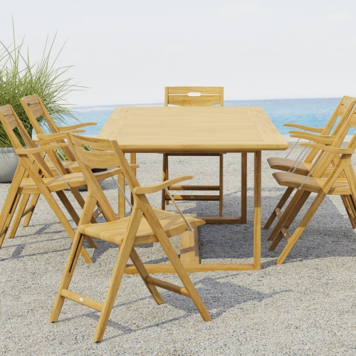  70382 Horizon Surf Dining Set for 6 of Horizon Rectangular Dining Table and 6 Surf Folding Dining Armchairs end view on stone patio with potted plant and the ocean in the background