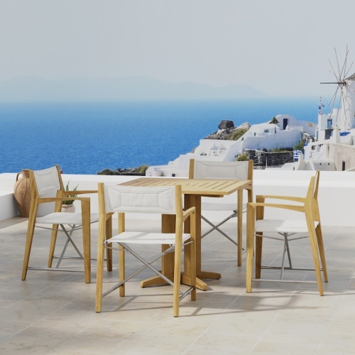 70455 Odyssey Pyramid 5 piece Bistro Set of Pyramid 36 inch Square Table and 4 Odyssey Folding Chairs on outdoor terrace with houses and the ocean and blue sky in the background