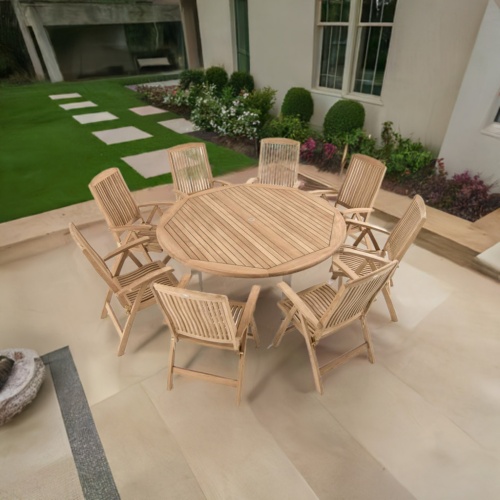 70485 Vogue Reclining Dining Set for 8 of a Vogue 72 inch Teak Round Table and 8 Barbuda Reclining Teak Chairs in angled aerial view on a stone patio with a house and plants in the background 