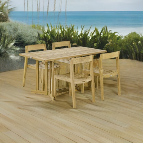 70610 Nevis Horizon 5 pc Dining Set of Nevis table and 4 Horizon Dining Chairs angled on wood deck with the ocean and blue sky in the background