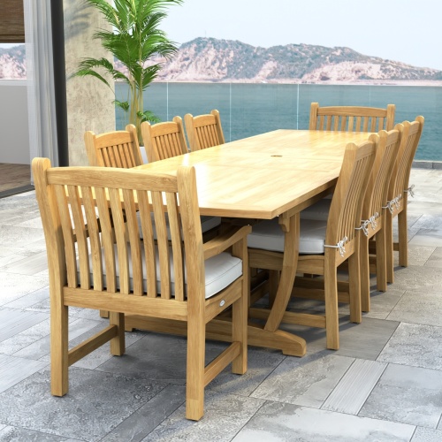 70792 Veranda 9 pc Teak Dining Set of Veranda Rectangular Extending Dining Table and 2 Dining Arm Chairs and 6 Side Chairs with optional seat cushions and a potted plant and ocean view background