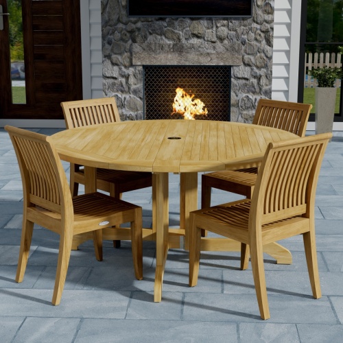 70851 Barbuda Laguna 5 pc Dining Set of Barbuda Folding Teak Table and 4 Laguna Side Chairs angled corner view on stone patio with 2 doors and a lit fireplace in the background