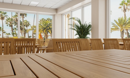 15815 Square 36 inch Pyramid Teak Table showing closeup of table top in hospitality setting with windows and trees in background 