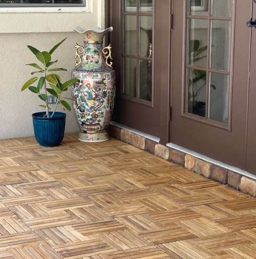 18412P Parquet Teak Tiles assembled on a outdoor patio with french door and tall vase and potted plant  in background 