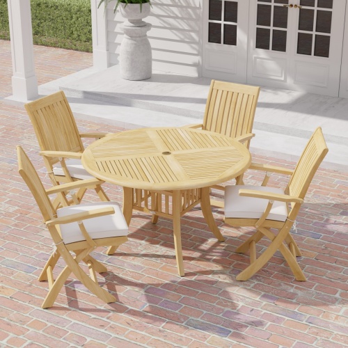 70043 Grand Hyatt Barbuda 5 pc Patio Dining Set of Grand Hyatt Dining Table and 4 Barbuda Folding Chairs angled aerial view on a brick patio with french doors and fern in background