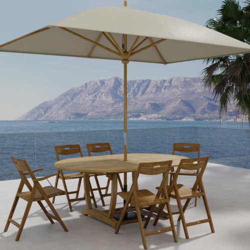 70371 Oval Surf Chair 7pc Dining Set angled aerial view with opened optional rectangular umbrella on outdoor terrace with the ocean and mountain background 