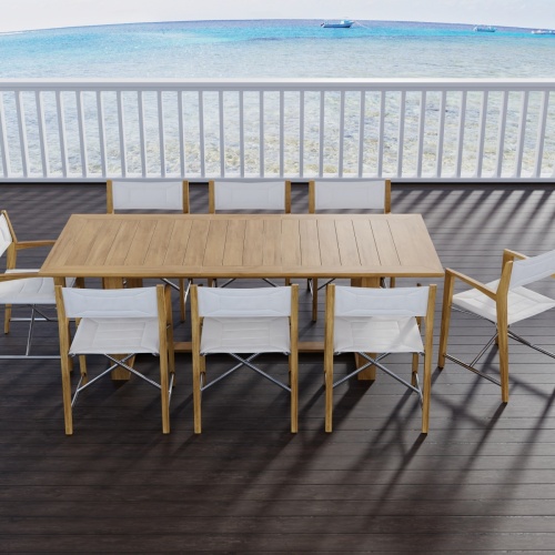 70366 Oval Odyssey Chair 7 pc Dining Set angled aerial view with opened optional black umbrella on outdoor terrace next to palm tree with the ocean and mountain background 