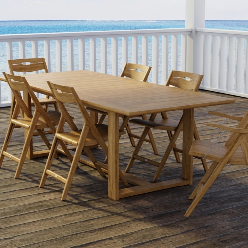 70378 Horizon Surf 7 pc Dining Set of Horizon Dining Table and 2 Surf Folding Dining Armchairs and 4 Side Chairs on wood patio with white deck railings and the ocean in the background