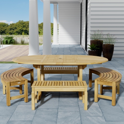 70380 Martinique 5pc Bench Dining Set of Teak Oval Dining Table and 2 Backless Curved Benches and 2 Backless Stools on outdoor patio with privacy wall and plants in background