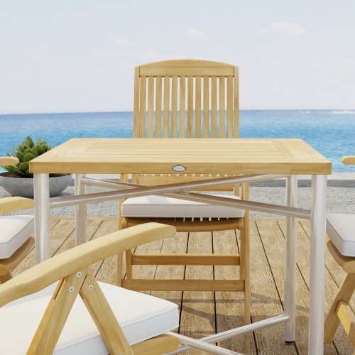 70381 Odyssey Recliner Foldable 5 pc Dining Set of Odyssey Table and 4 Barbuda Folding Chairs with optional seat cushions showing closeup side view on wood deck with ocean in background