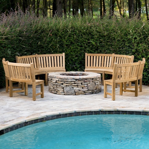 13852 Buckingham 6 foot Teak Bench Set of 4 around firepit showing a pool in front and bushes in back