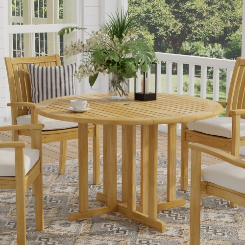 15623S Barbuda 4 foot Table showing vase and coffee cup and candle on table and 4 Sussex Dining Chairs on outdoor patio with french doors and trees in background