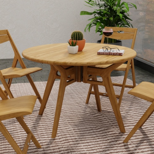 15629 Surf 42 inch Foldable Table with 2 potted plants and book on table top and 4 Surf Folding Chairs on rug with potted plant in the background 