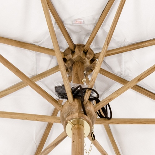 17542 teak round ten foot market table umbrella with white canvas canopy extended  inside construction showing arms shaft and black rope atop the hub