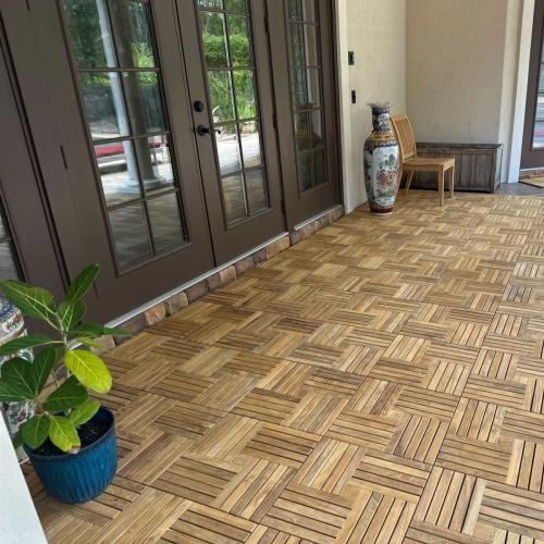 18412P parquet teak tiles assembled on a outdoor patio with french door and potted palm and tall vase in corner against a house