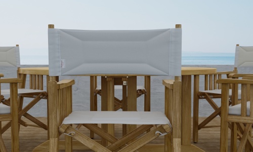 70362 Barbuda Director Teak Dining Set Director Chair showing closeup of chair back on outdoor patio facing a white wall and ocean in background