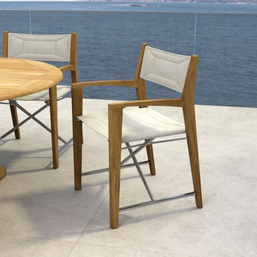 70366 Oval Odyssey Chair 7 pc Dining Set on outdoor terrace showing closeup view of 2 chairs and partial view of table with ocean background 