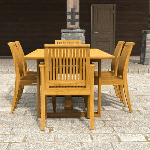 70377 Horizon Laguna 7 pc Teak Dining Set showing end view on paver patio with stone and wood pillars and wall and door in the background 