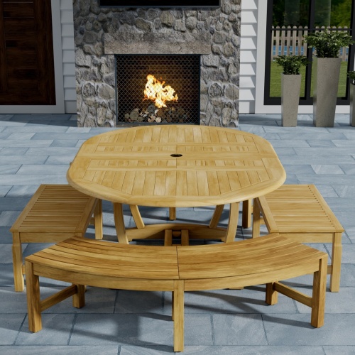 70380 Martinique 5pc Bench Dining Set of Teak Oval Dining Table and 2 Backless Curved Benches and 2 Backless Stools on outdoor patio with fireplace and potted plants in background 